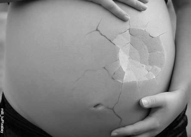 Fotomontaje de una barriga de embarazada a modo de cáscara de huevo