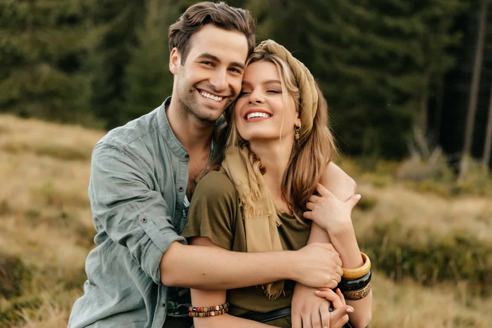 pareja joven sonriente posando en la naturaleza