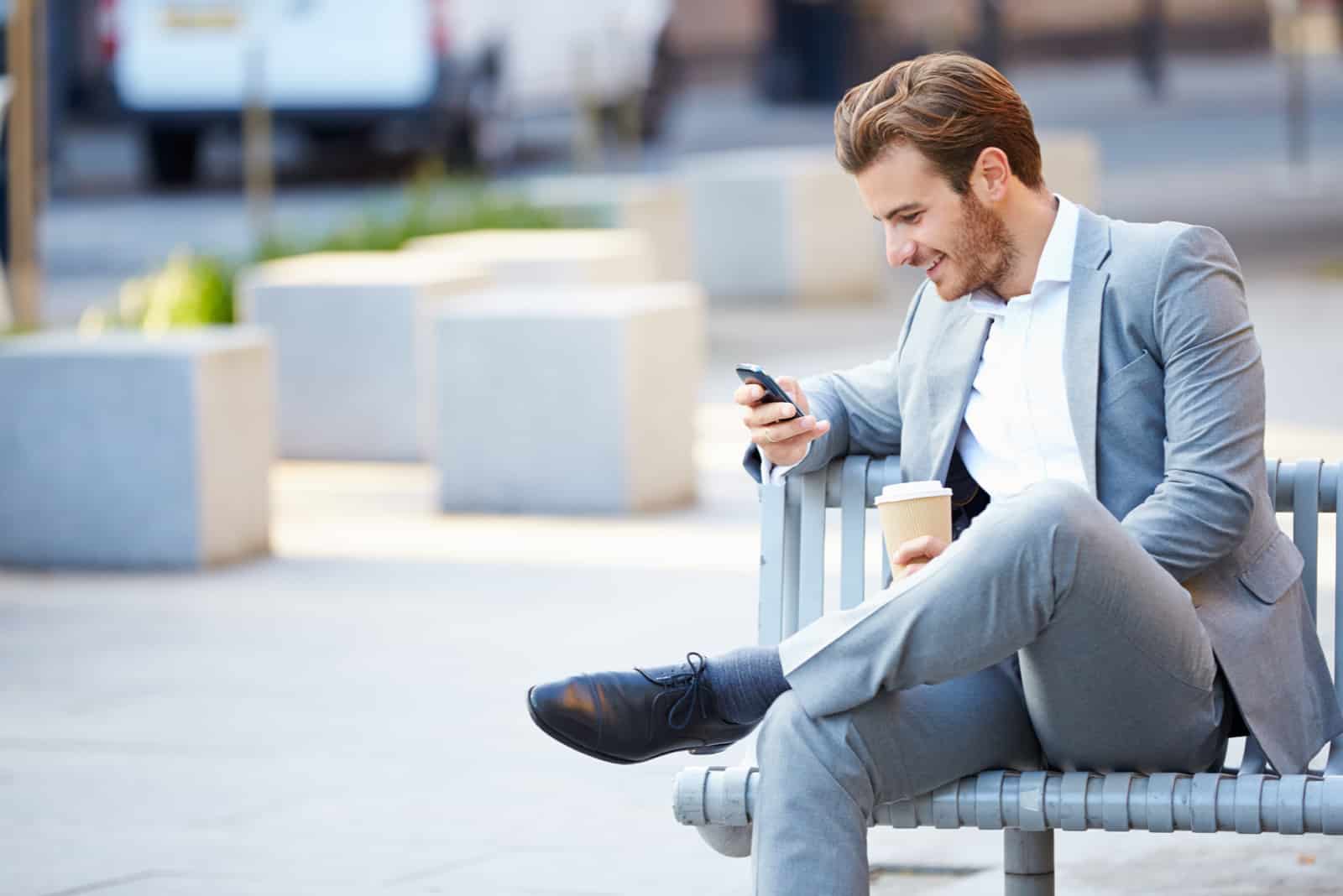 un hombre está sentado en un banco y un botón en el teléfono