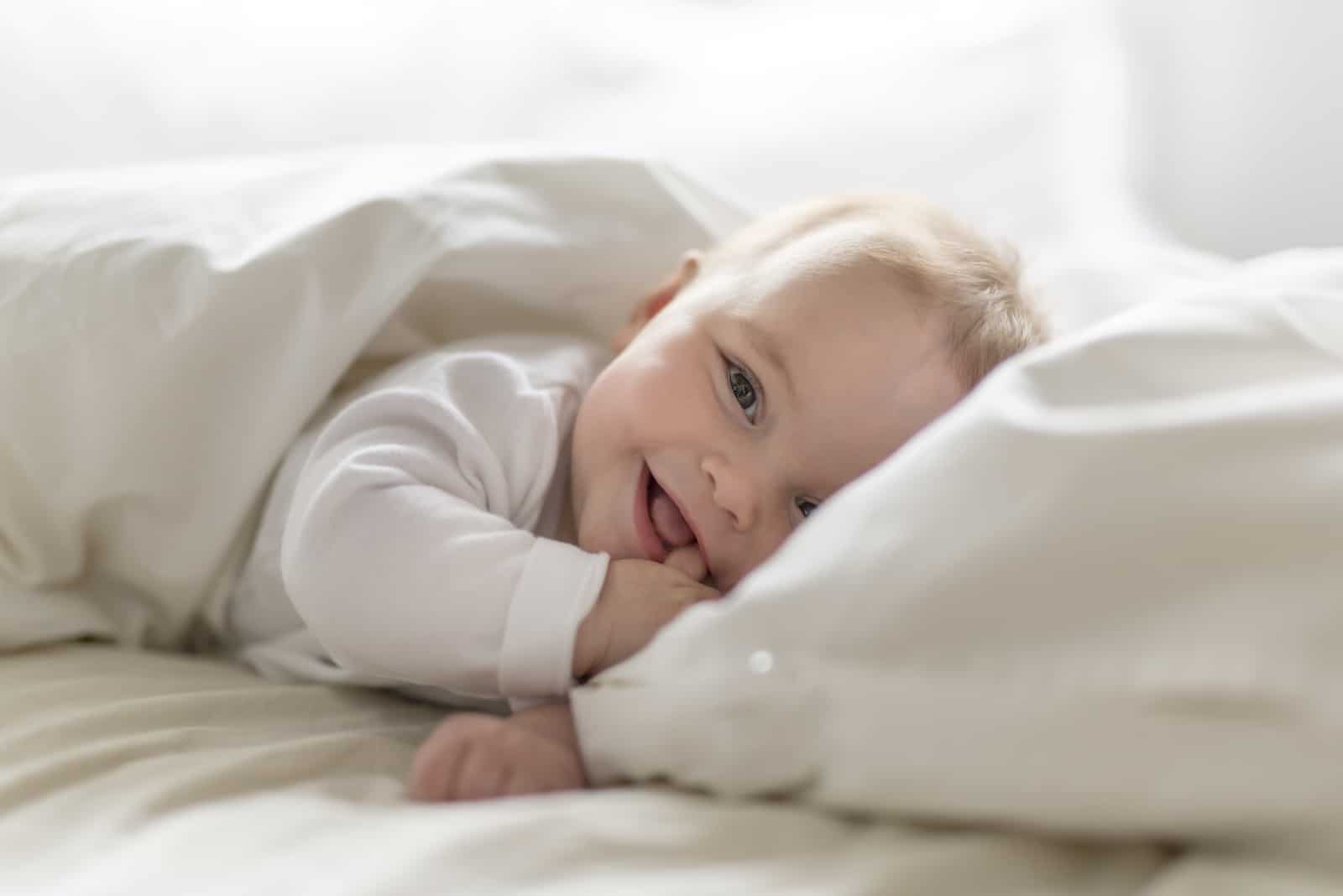 pequeño bebé acostado envuelto en sábanas