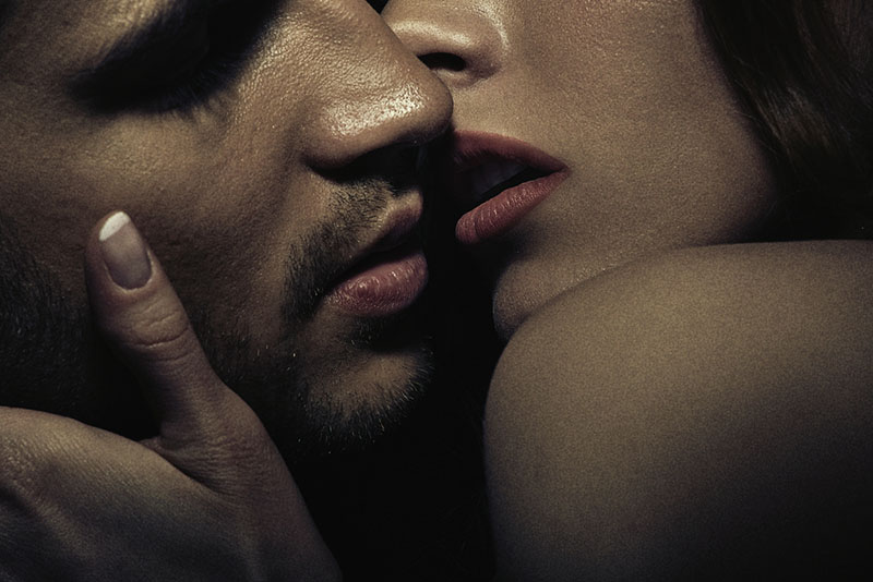 sensual pareja besándose en la oscuridad