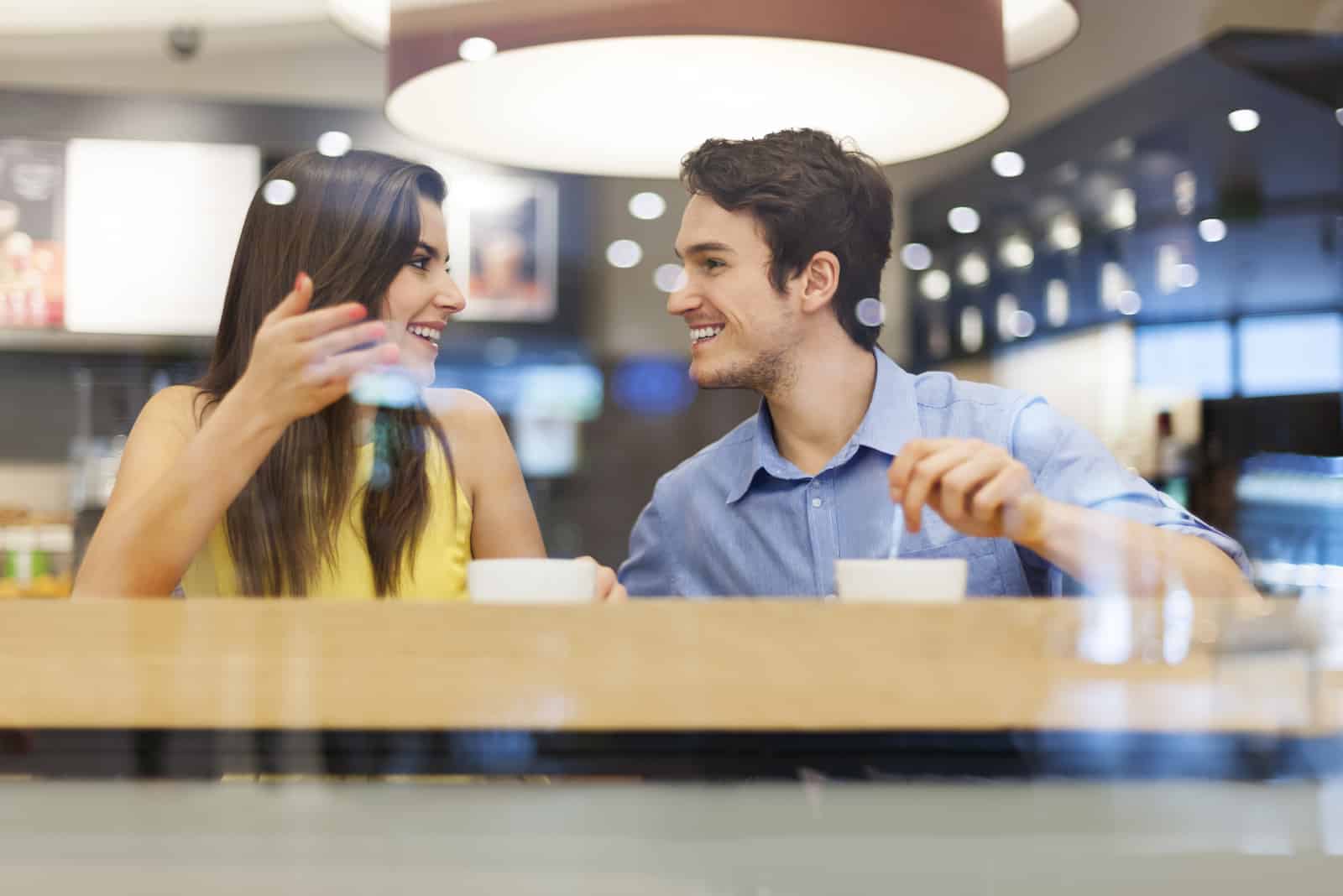 un hombre y una mujer están hablando en un café