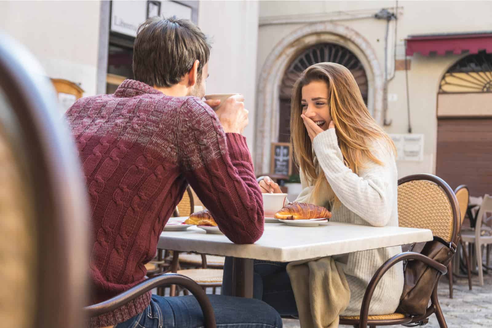 mujer riendo en café con hombre
