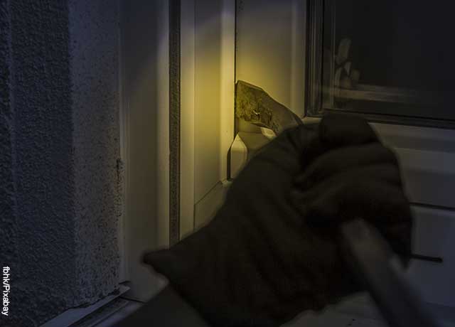 Foto de una mano enguantada abriendo una puerta y mostrando como es soñar con ladrones