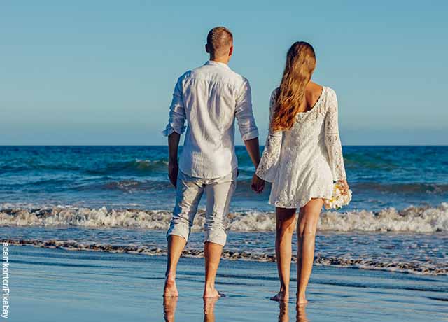 Foto de una pareja caminando de la mano en la playa y mostrando lo que significa soñar que tu ex novio regresa