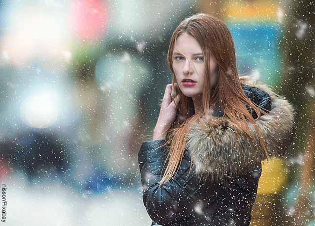Foto de una mujer en medio de una nevada que muestra cómo es soñar con nieve