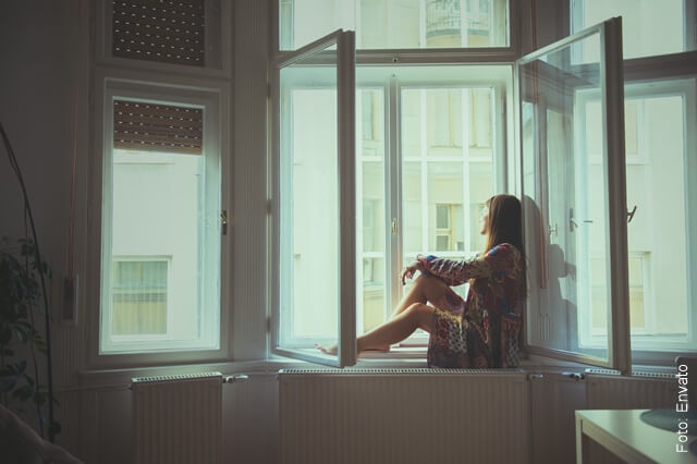 foto de una mujer triste y solitaria junto a la ventana