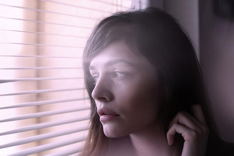 mujer joven mirando por la ventana