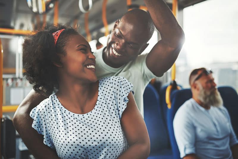joven pareja negra se encuentra en el bus