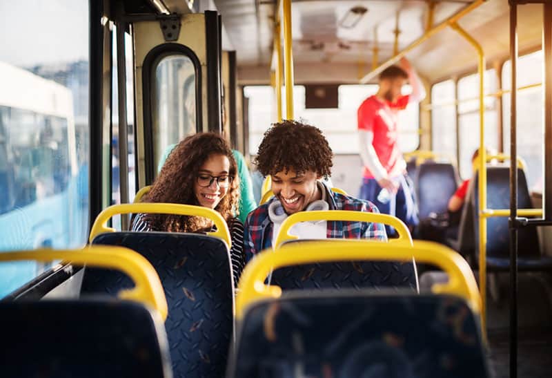 pareja adolescente hablando y riendo en el bus