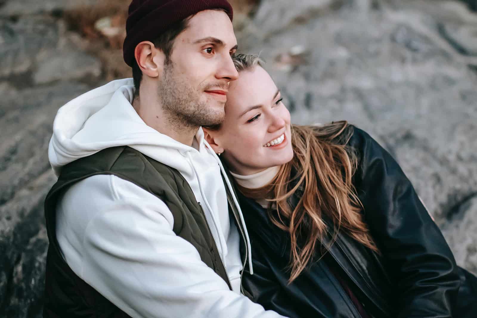 una pareja enamorada sentada en la roca abrazándose
