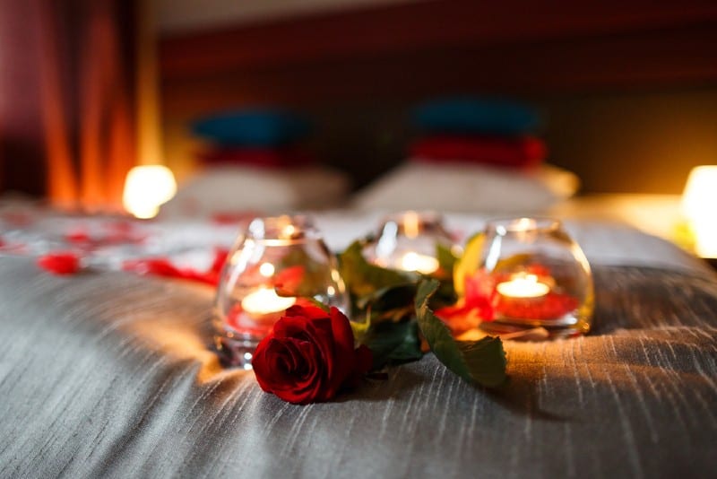 Dormitorio romántico con rosas y velas en la cama