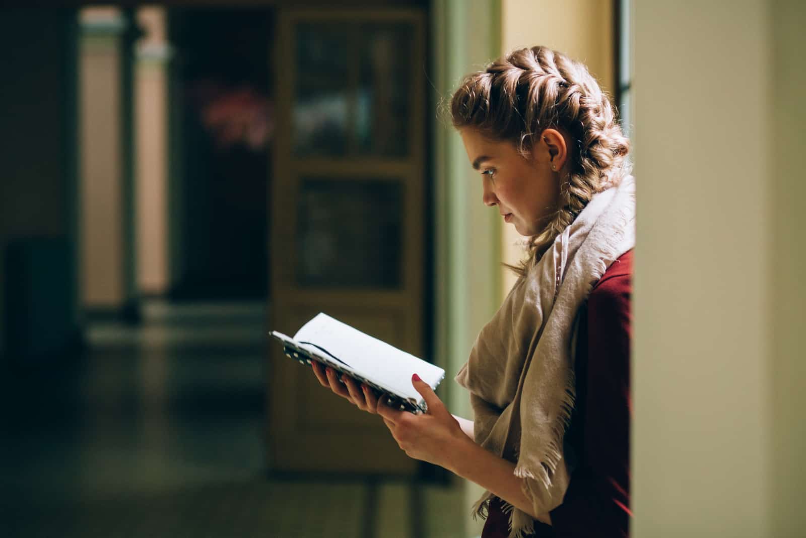 mujer abrumada se encuentra en el pasillo leyendo un libro